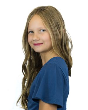 Girl in navy blue shirt with blonde hair poses for studio photos against white background.