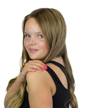 Person in black sleeveless top poses expressively with hand gestures against white background.