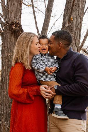 A tender family moment captured on a wooden bridge during golden hour.