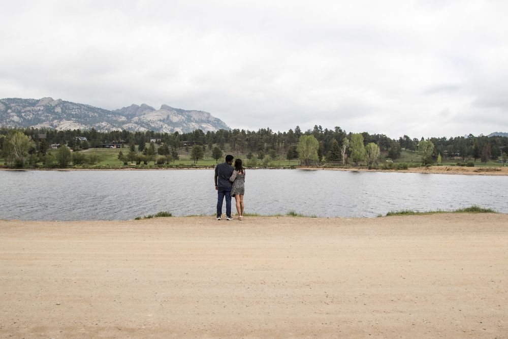 Scenic mountain landscape with a lake view and distant figures on the shoreline.