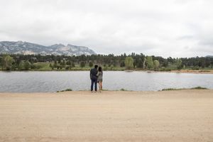 Scenic mountain landscape with a lake view and distant figures on the shoreline.