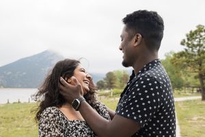 Intimate couple's moment captured against a scenic mountain lake backdrop.