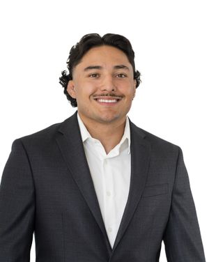 Professional headshot showing person in business attire smiling warmly.