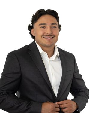 Business portrait of person in dark suit jacket adjusting lapel.