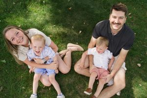 Family enjoying a sunny day together on lush grass outdoors.