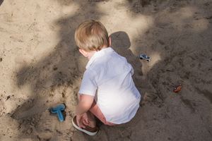 Children playing in a sandy area on a sunny day.