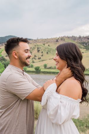 A tender moment between a couple laughing together in an outdoor setting.