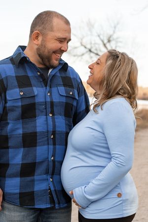 A couple in casual attire sharing joyful moments together outdoors on an autumn day.