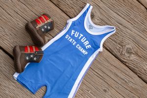 Blue and white sports jersey with red stripes on wooden deck background shows athletic apparel details.
