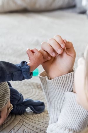 Two hands pull on a white knit sock in a series of progressive close-up shots showing sock fitting technique.