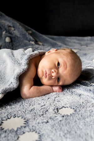 A series of six similar photos showing a baby lying on patterned bedding in different poses.