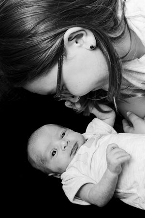 A tender black and white photo series showing intimate moments between a parent and baby in close-up portraits.