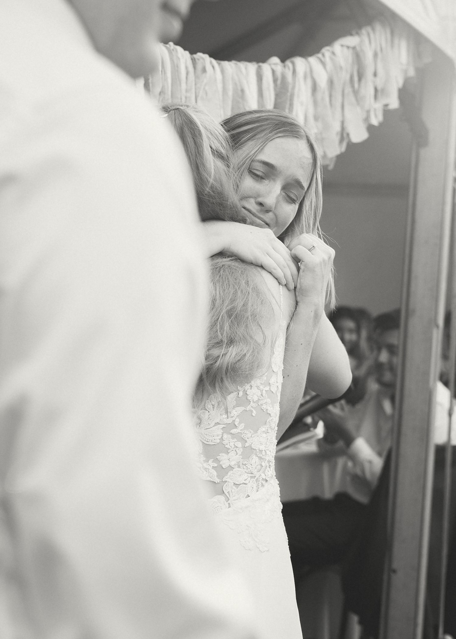 Series of monochrome photos showing a bride adjusting her dress in front of a mirror.