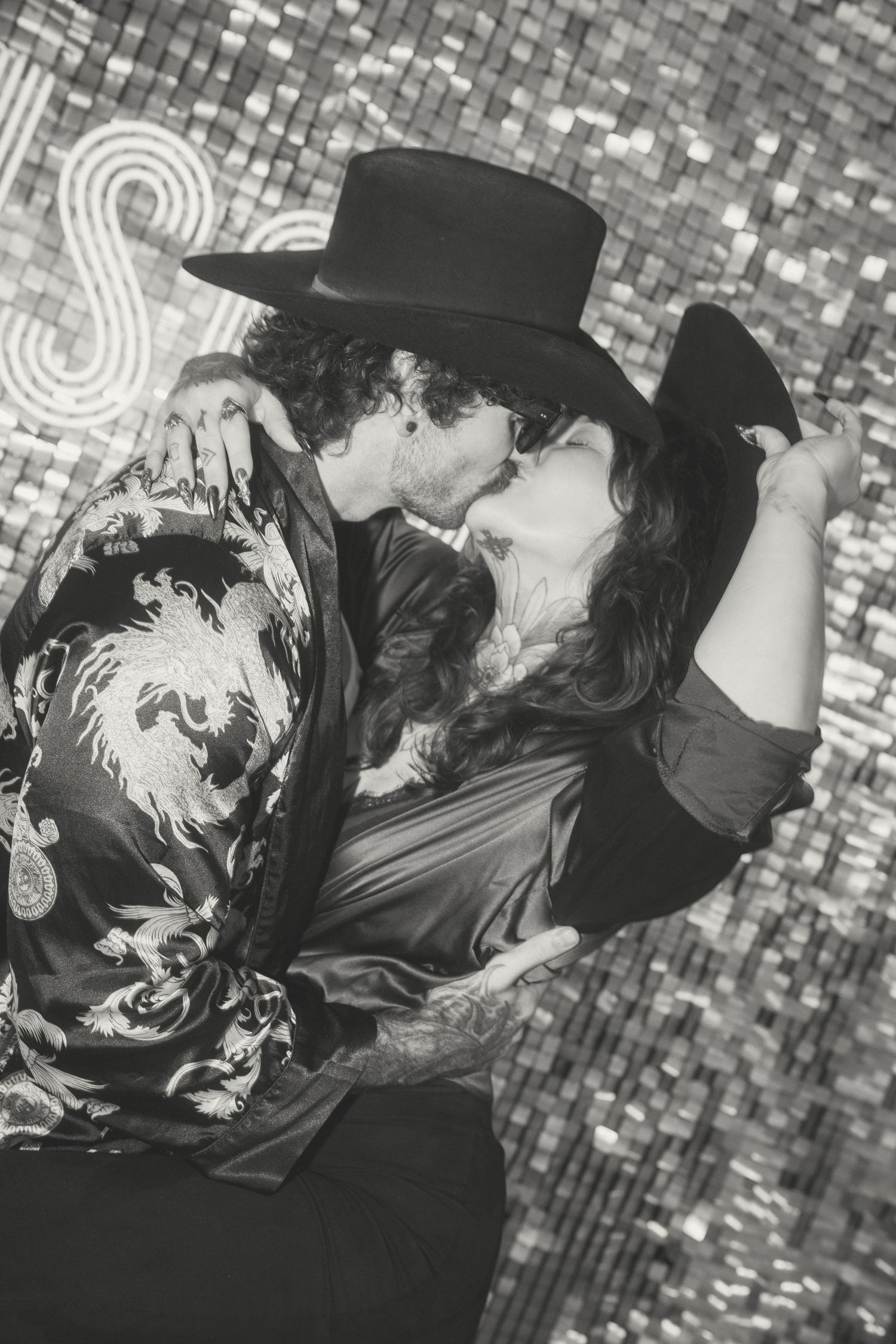 A black and white sequence showing a romantic couple in vintage attire sharing an intimate moment on a checkered surface.