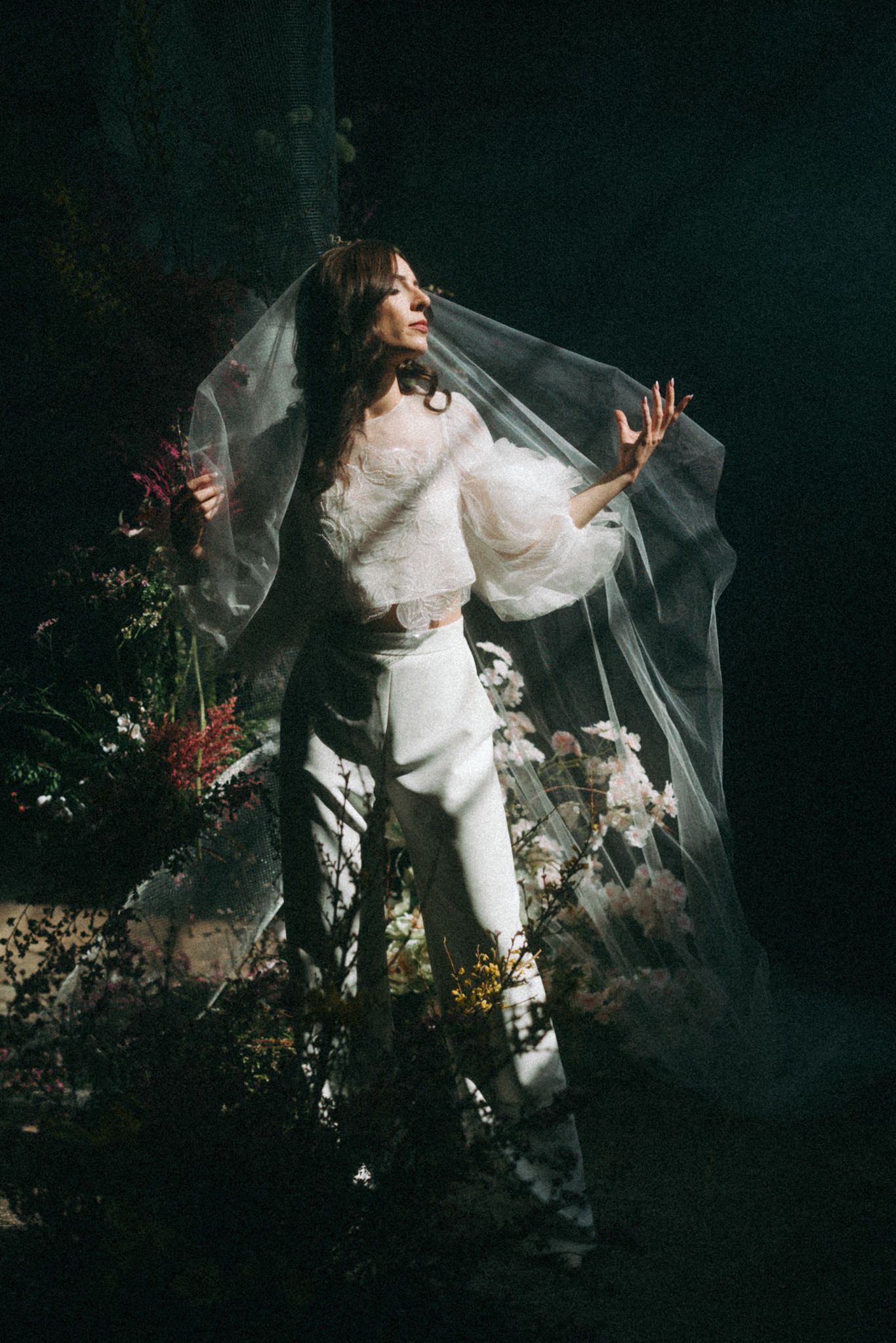 Artistic portrait series featuring ethereal movement with flowing white fabric and dark floral backdrop.