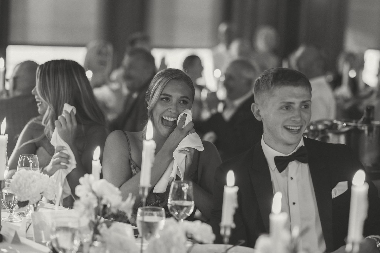 Wedding reception guests enjoying dinner at elegantly decorated tables.