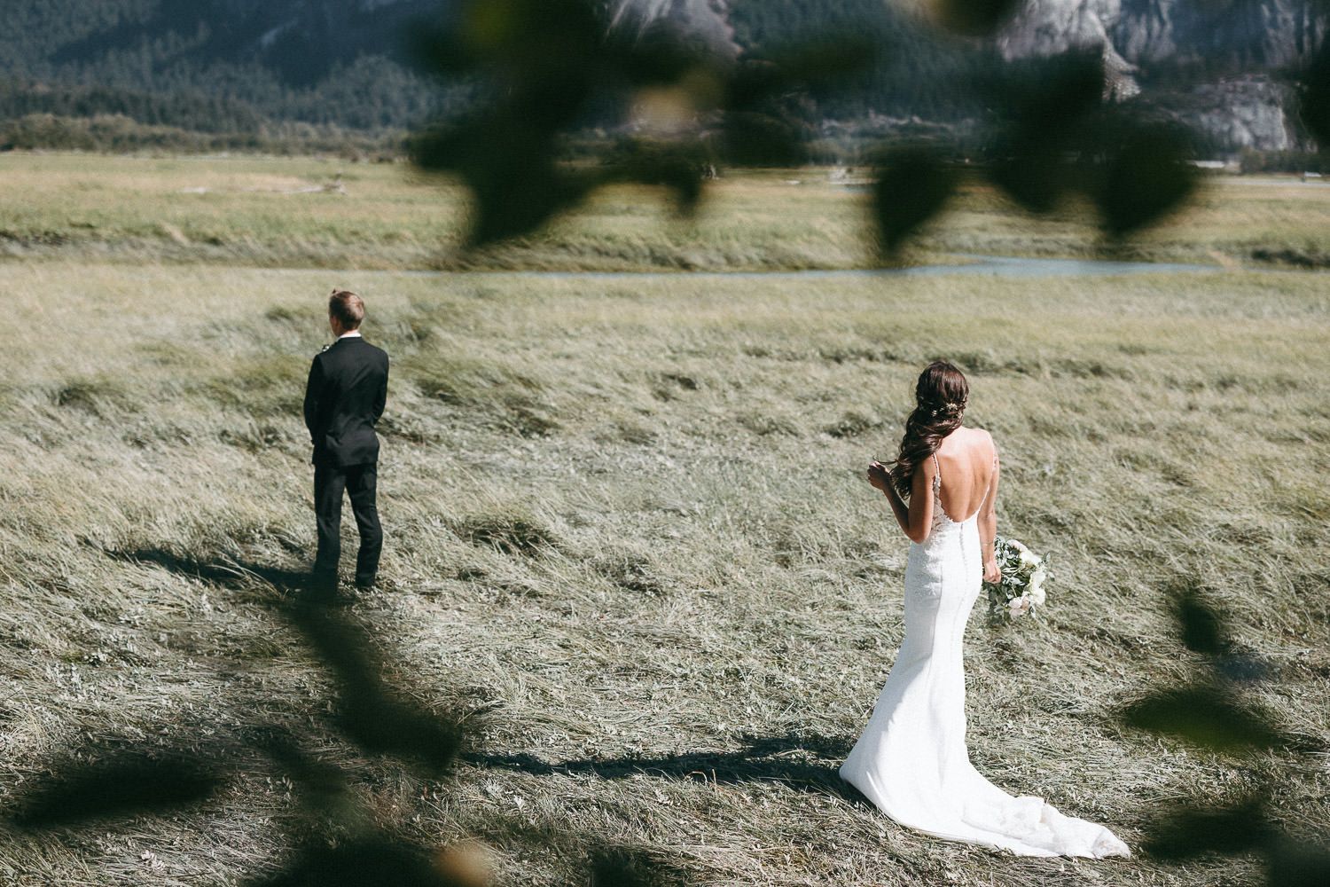 Scenic outdoor wedding photography sequence in mountain meadow setting.