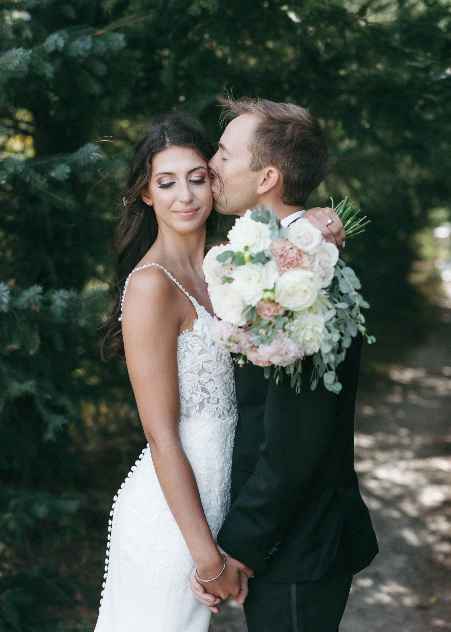 Romantic wedding portraits in garden setting with lush bouquet.
