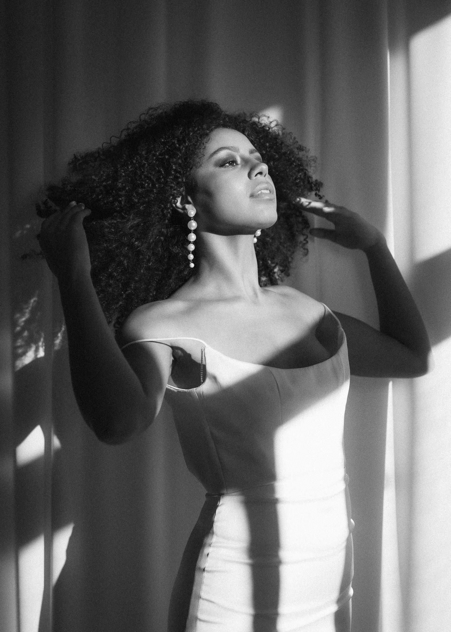 Artistic black and white portrait series showing dramatic poses against window light.