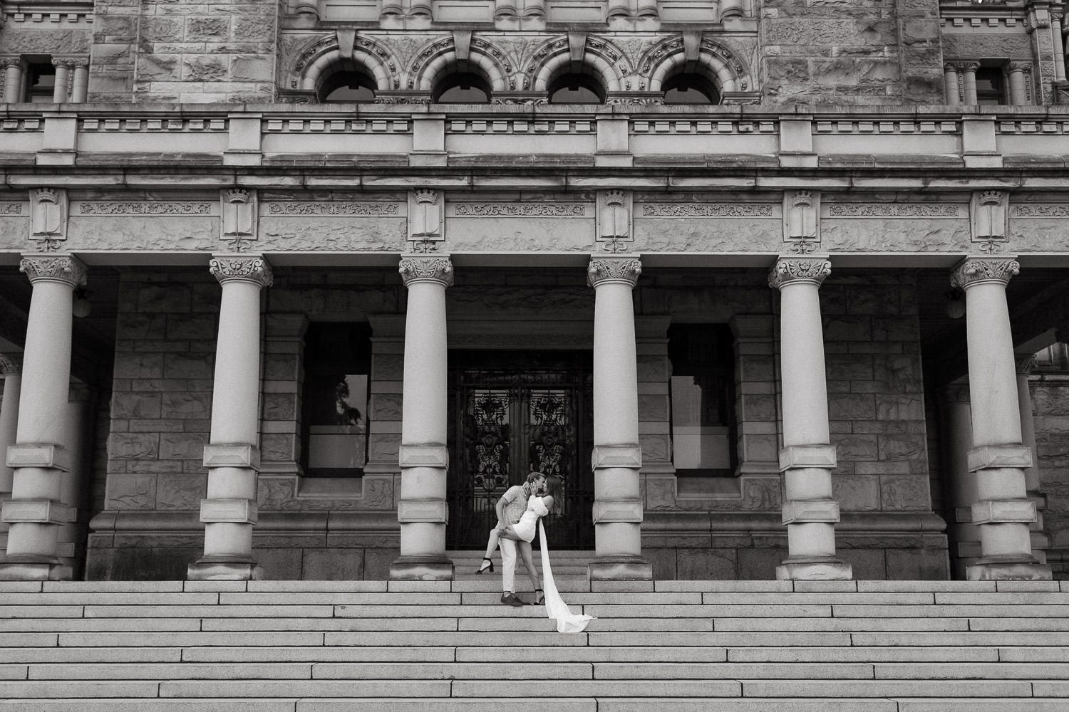 Historic stone building facade with classical architectural columns and arches stretching across the frame.