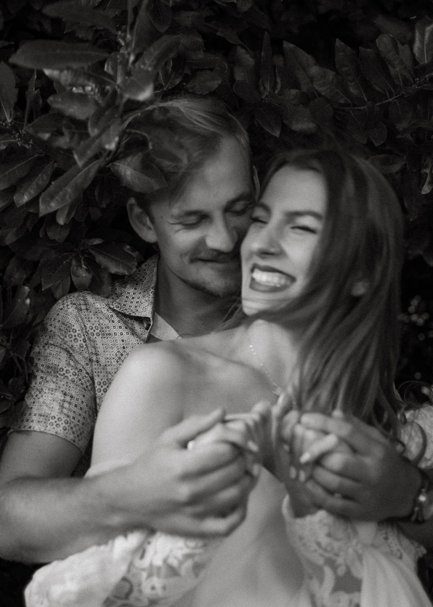 Intimate black and white romantic portraits among foliage and natural elements.
