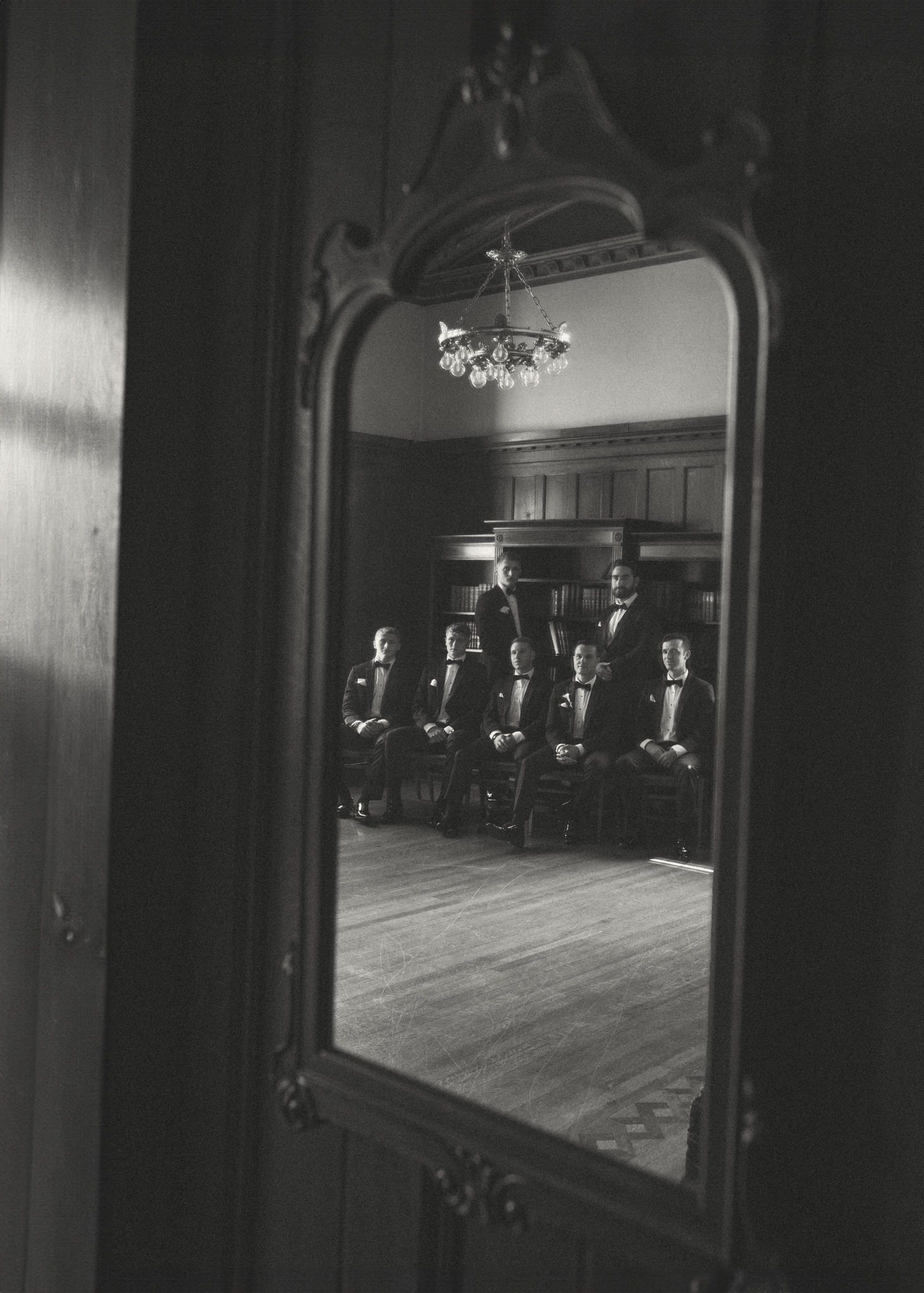 Vintage mirror reflection in dark room with ornate wooden frame.
