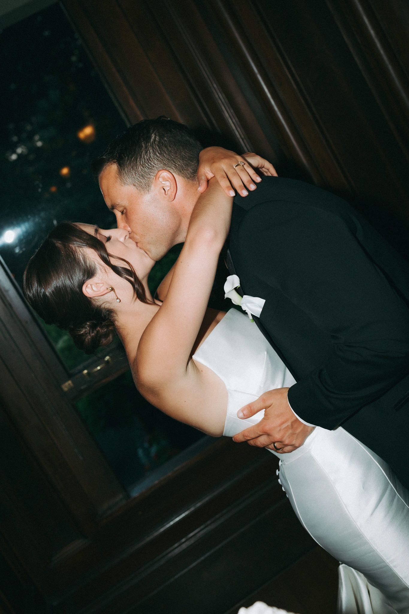 A romantic dip kiss between newlyweds at their wedding reception.