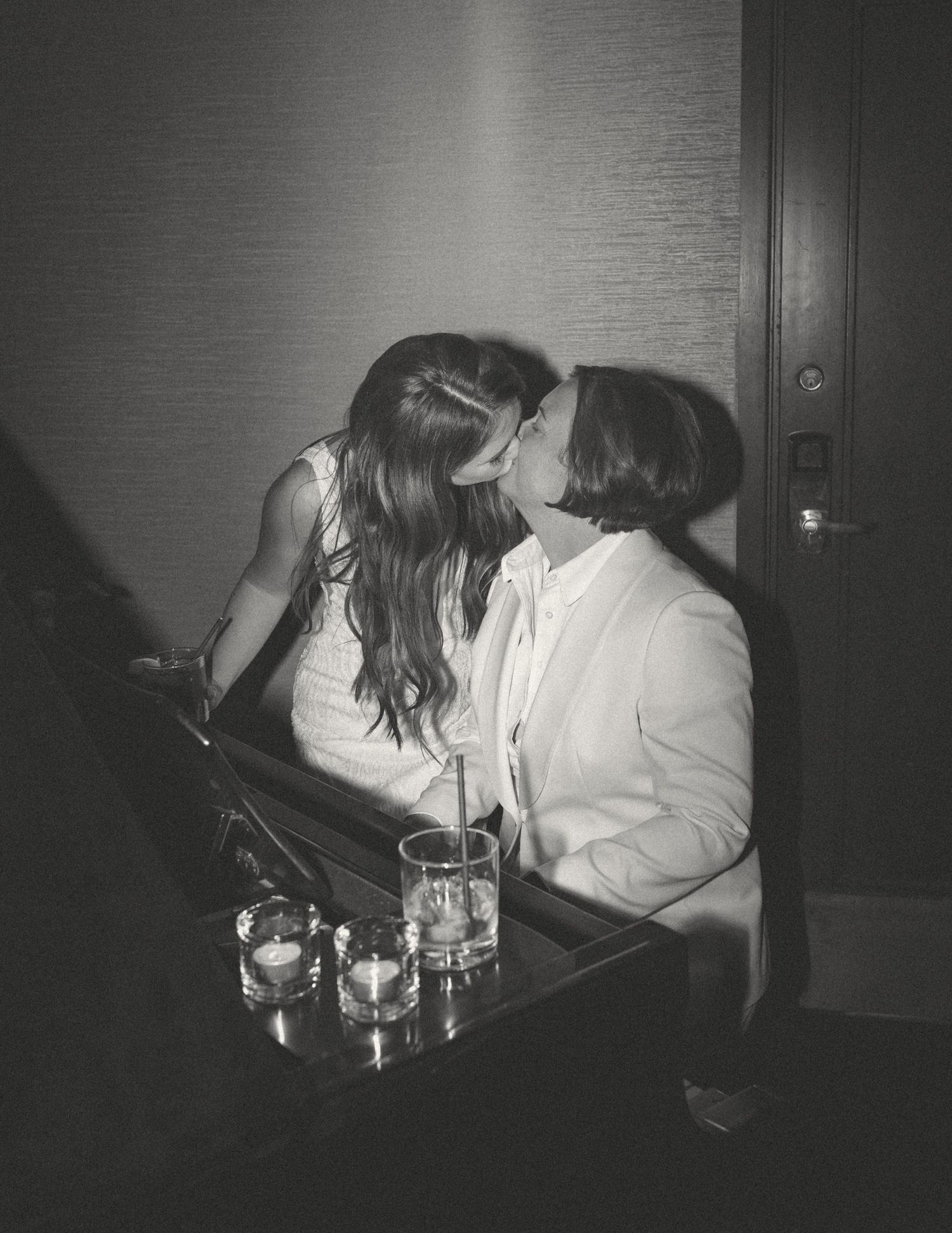 Black and white candid photo of intimate moment at dimly lit table.