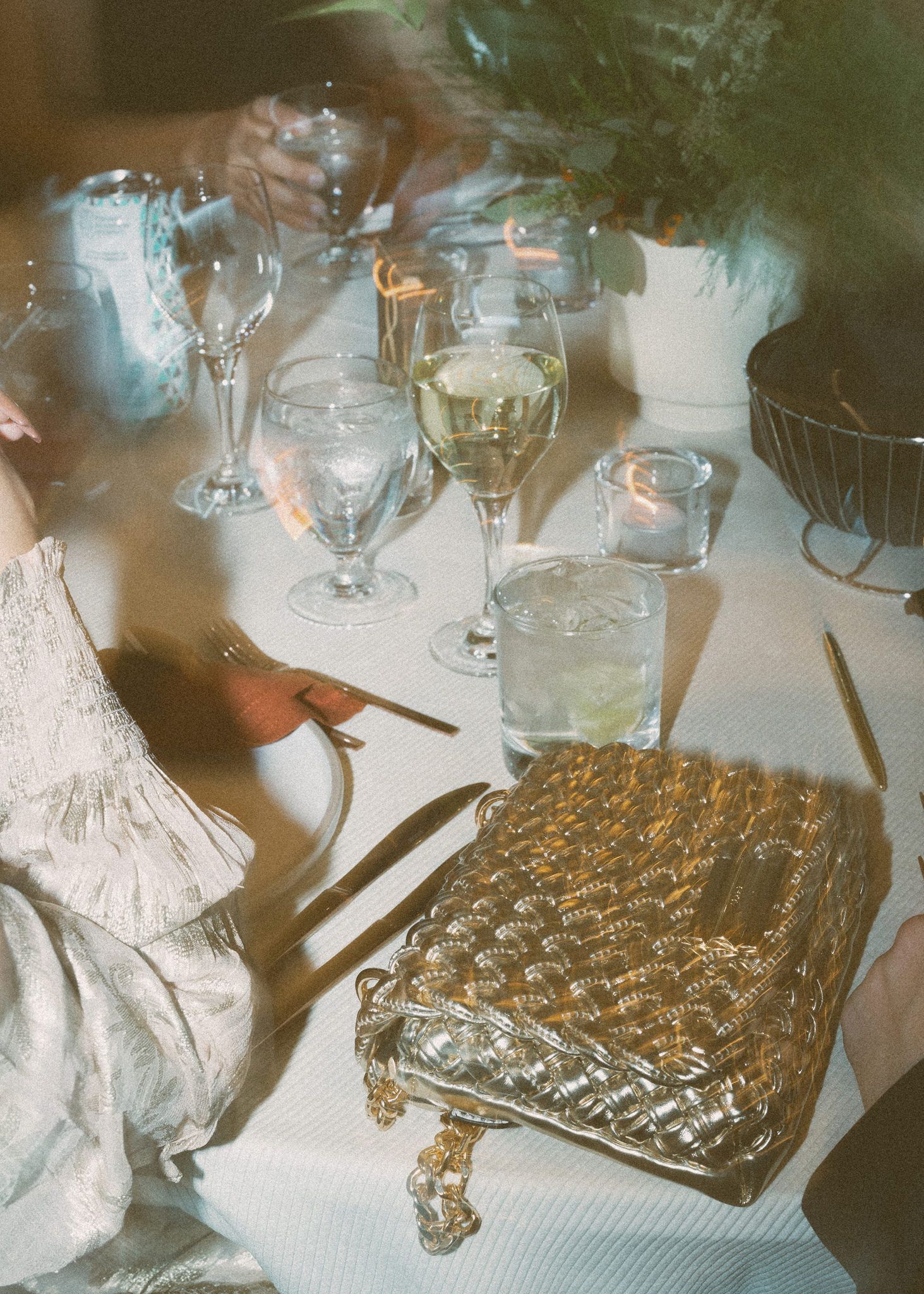 Vintage-style wedding reception detail showing metallic quilted clutch purses and glassware.