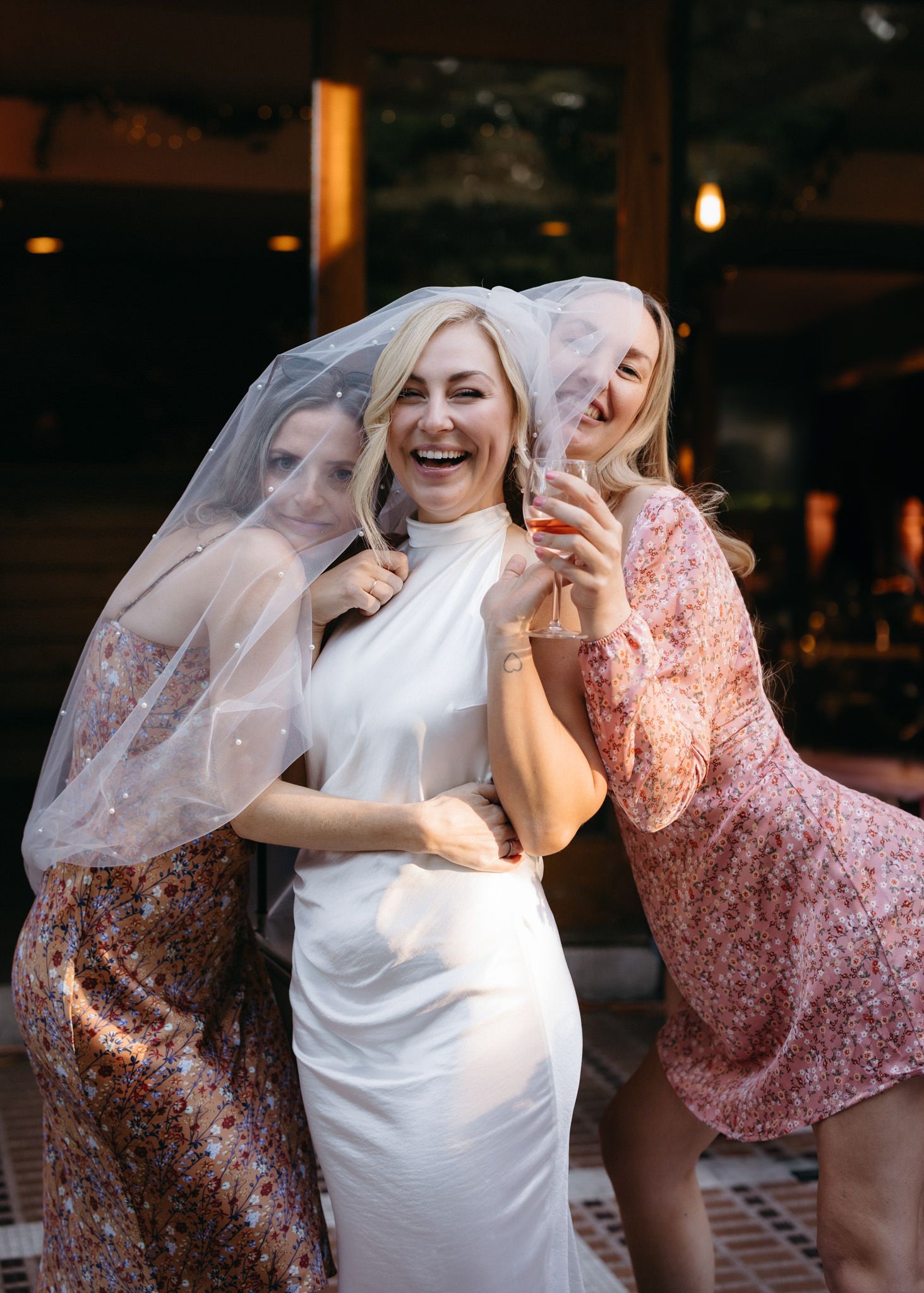 Joyful bridal celebration with friends in floral dresses.