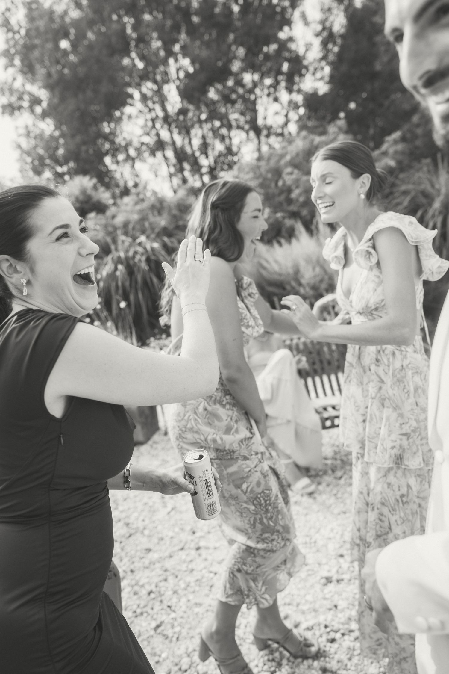 A sequence of five black and white photos showing joyful dancing and movement outdoors in a natural setting.