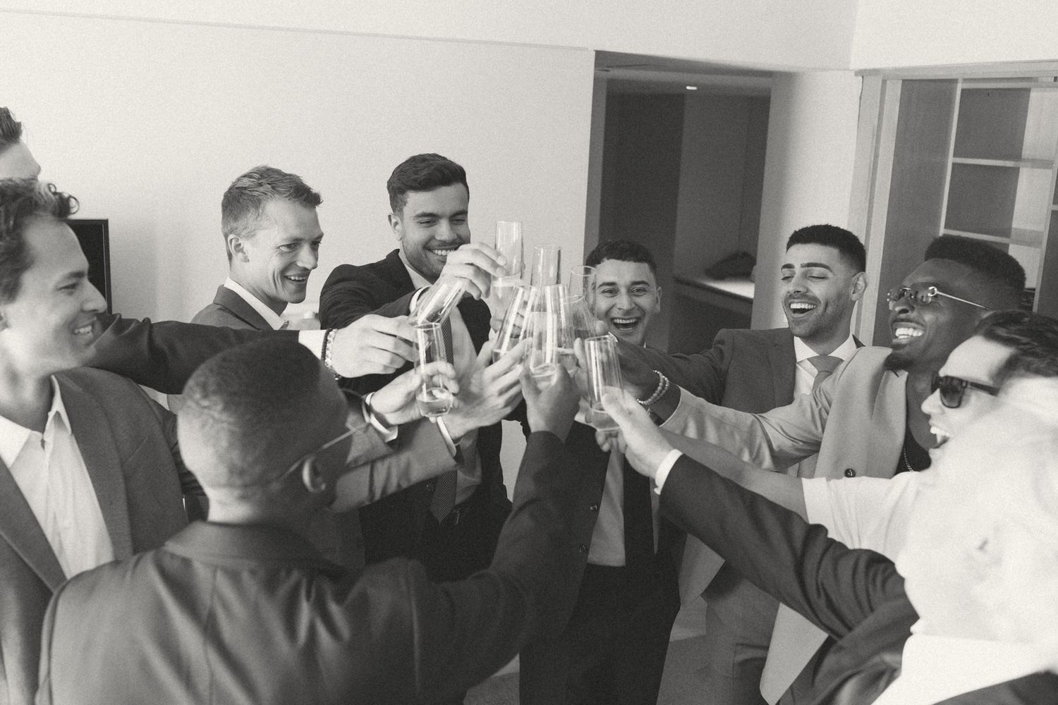 Group of people celebrating and laughing together at a formal event.