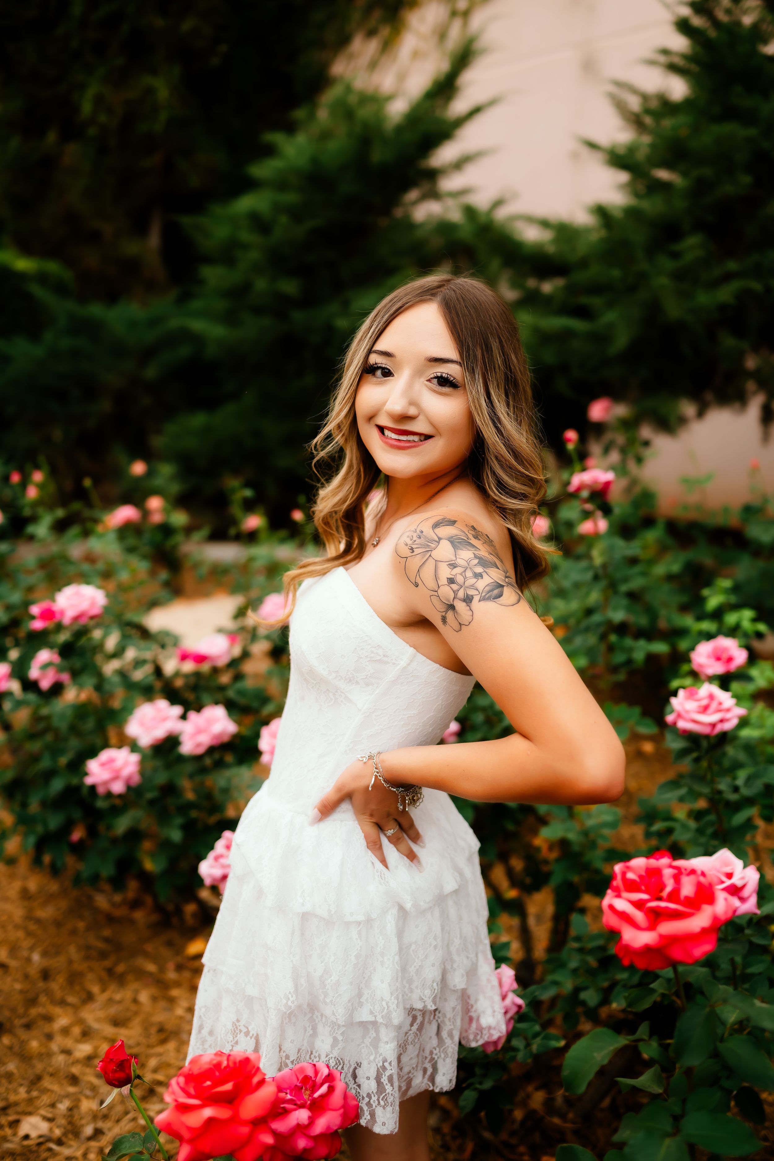 Tucson senior photographer portraits of high school senior in white lace dress surrounded by pink roses