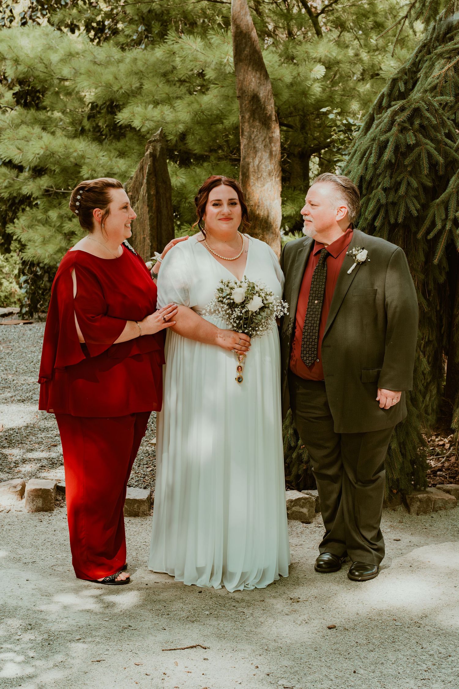 Wedding party in formal attire sharing a lighthearted moment outdoors.