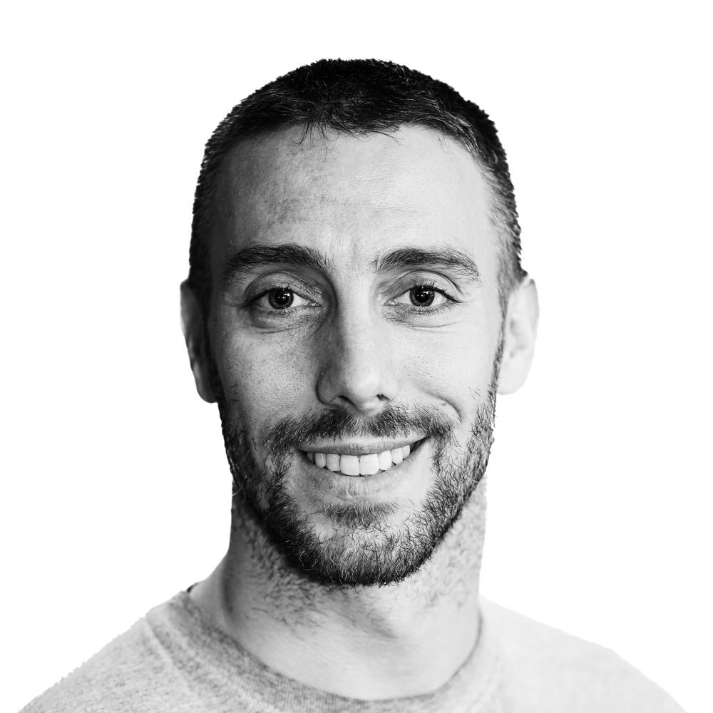 Professional headshot portrait in black and white with a friendly smile.
