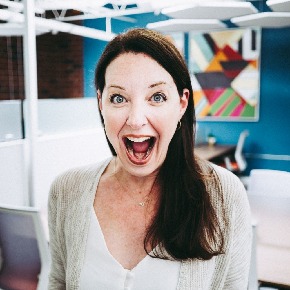 Enthusiastic person expressing excitement in modern office setting with geometric wall art.