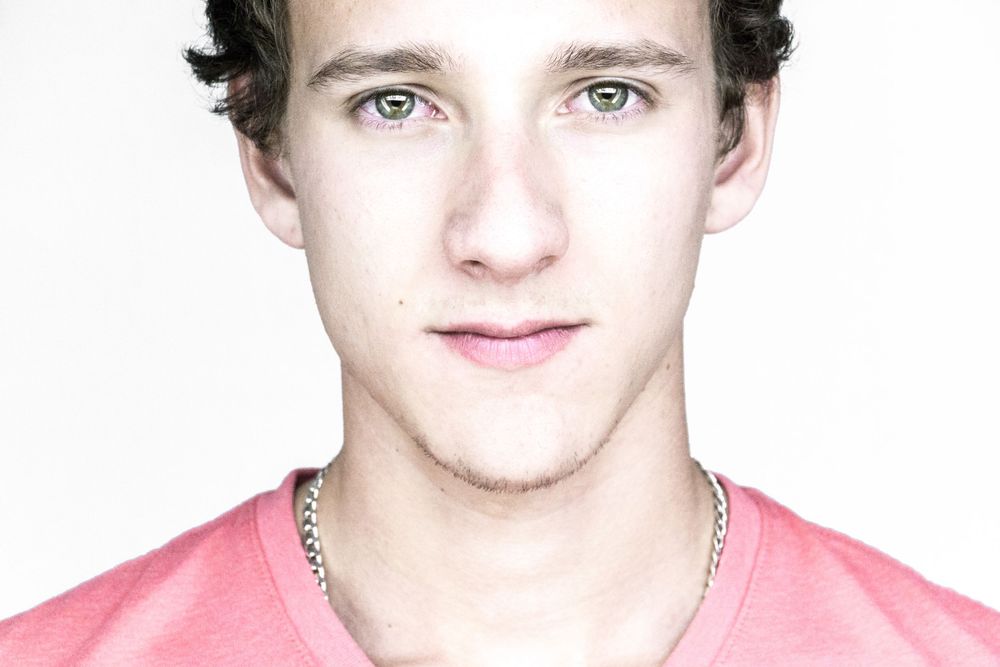 Portrait of a person in a pink shirt against a white background.