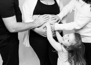 Pregnant woman in elegant flowing fabric posing in Bradenton luxury studio maternity portrait with soft light and timeless artistic style.