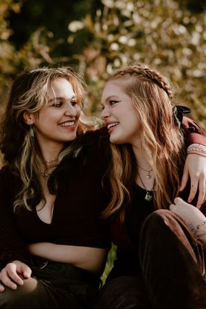 Close-up photo of two people sharing laughter and affection in dark clothing.