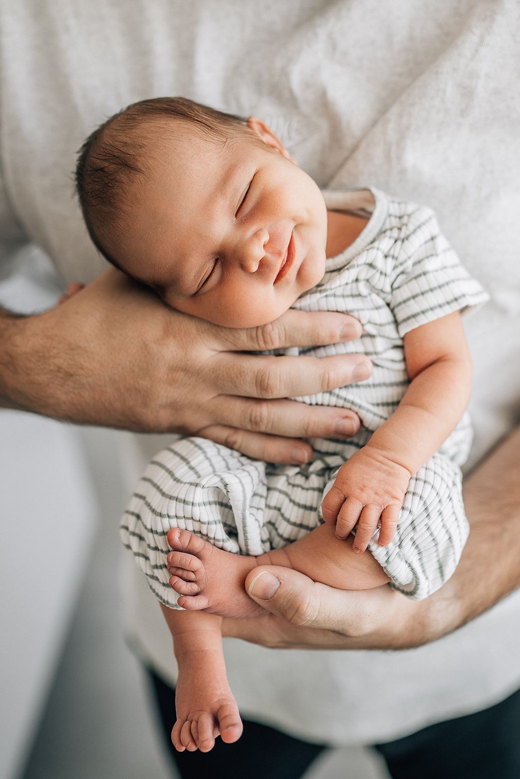 baby smiling in dad's hands