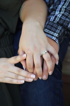 Close-up of hands with engagement ring showing affection.