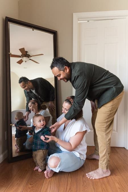 A family gathering reflected in a large mirror while getting ready at home.