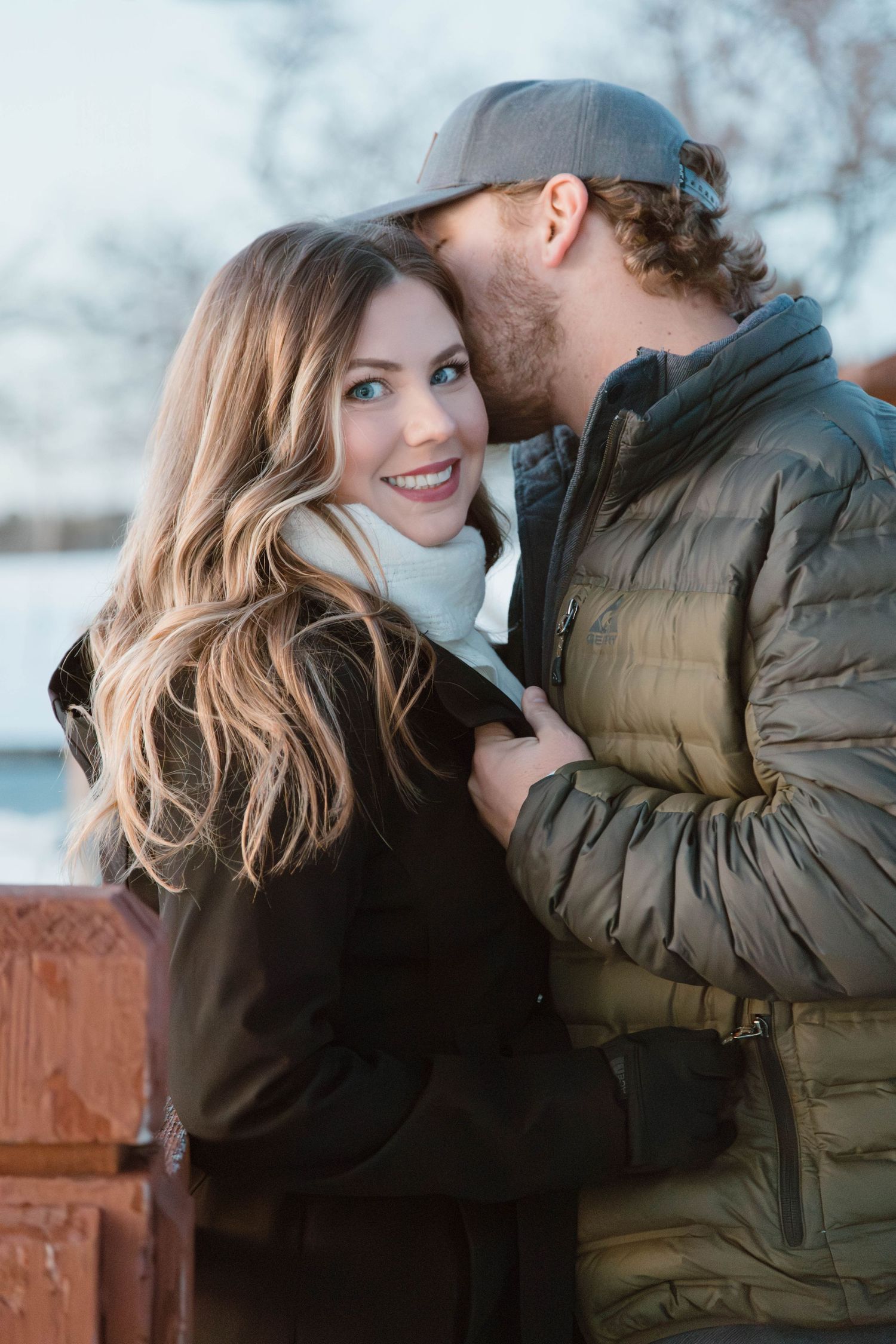 A romantic winter moment between a couple wearing coats as they share an intimate moment outdoors.