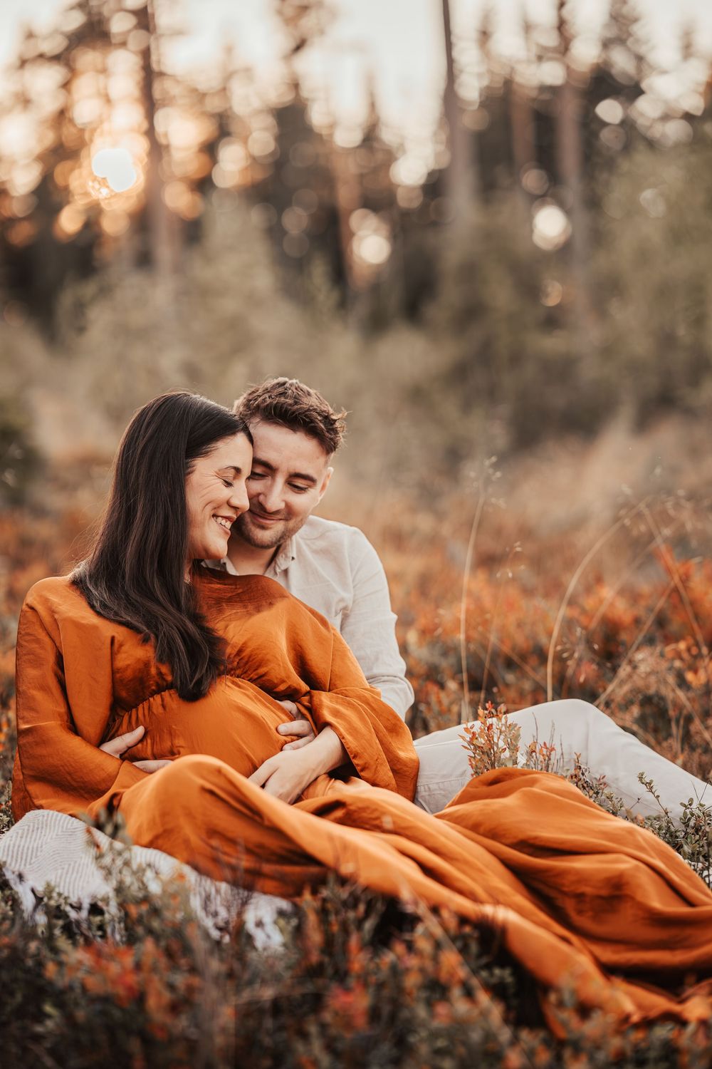 Couple in rustic autumn setting sharing intimate moments on ground with orange dress and white shirt in five panel sequence.