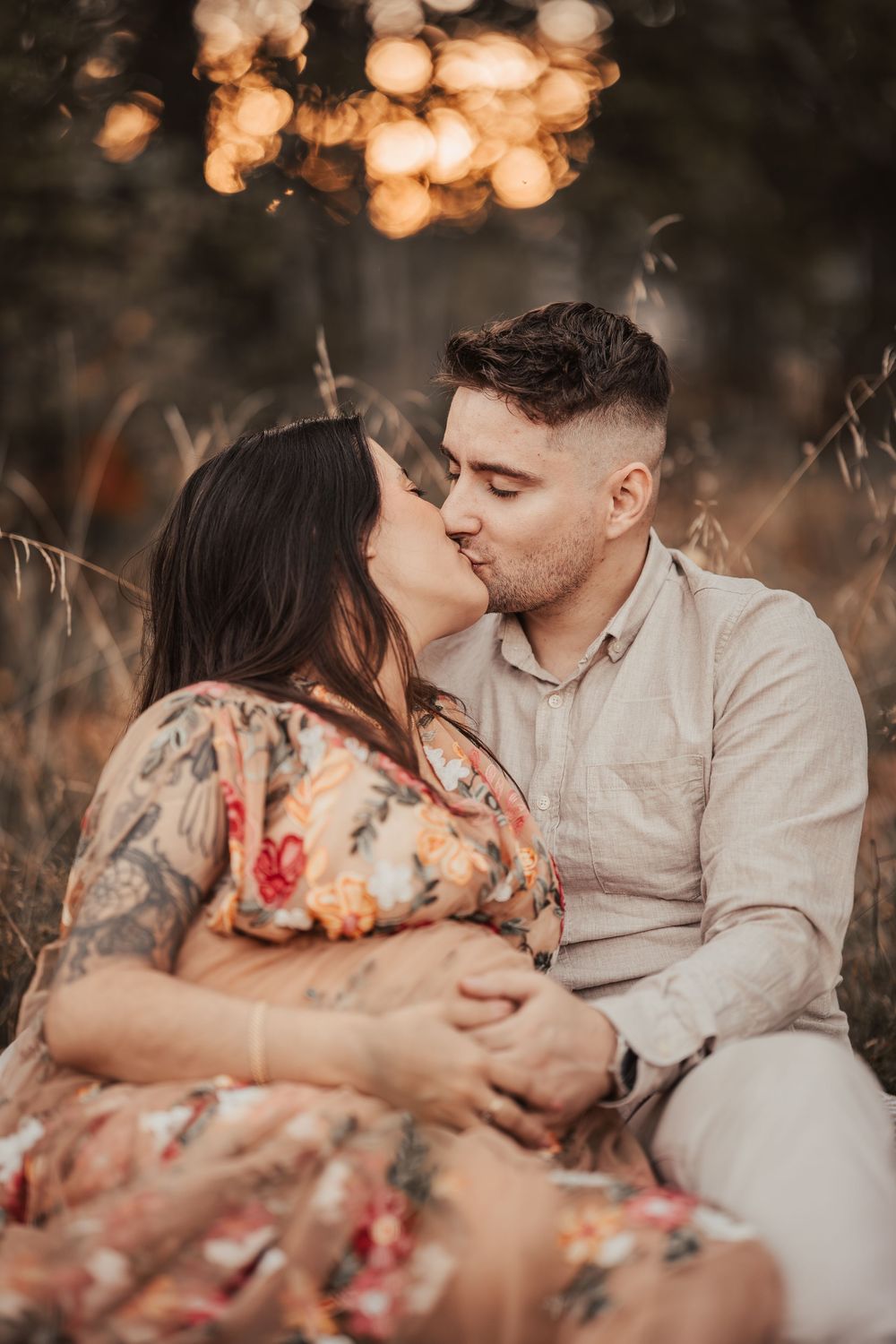 A romantic sunset photo session shows tender moments between a couple in floral dress and light colored shirt.