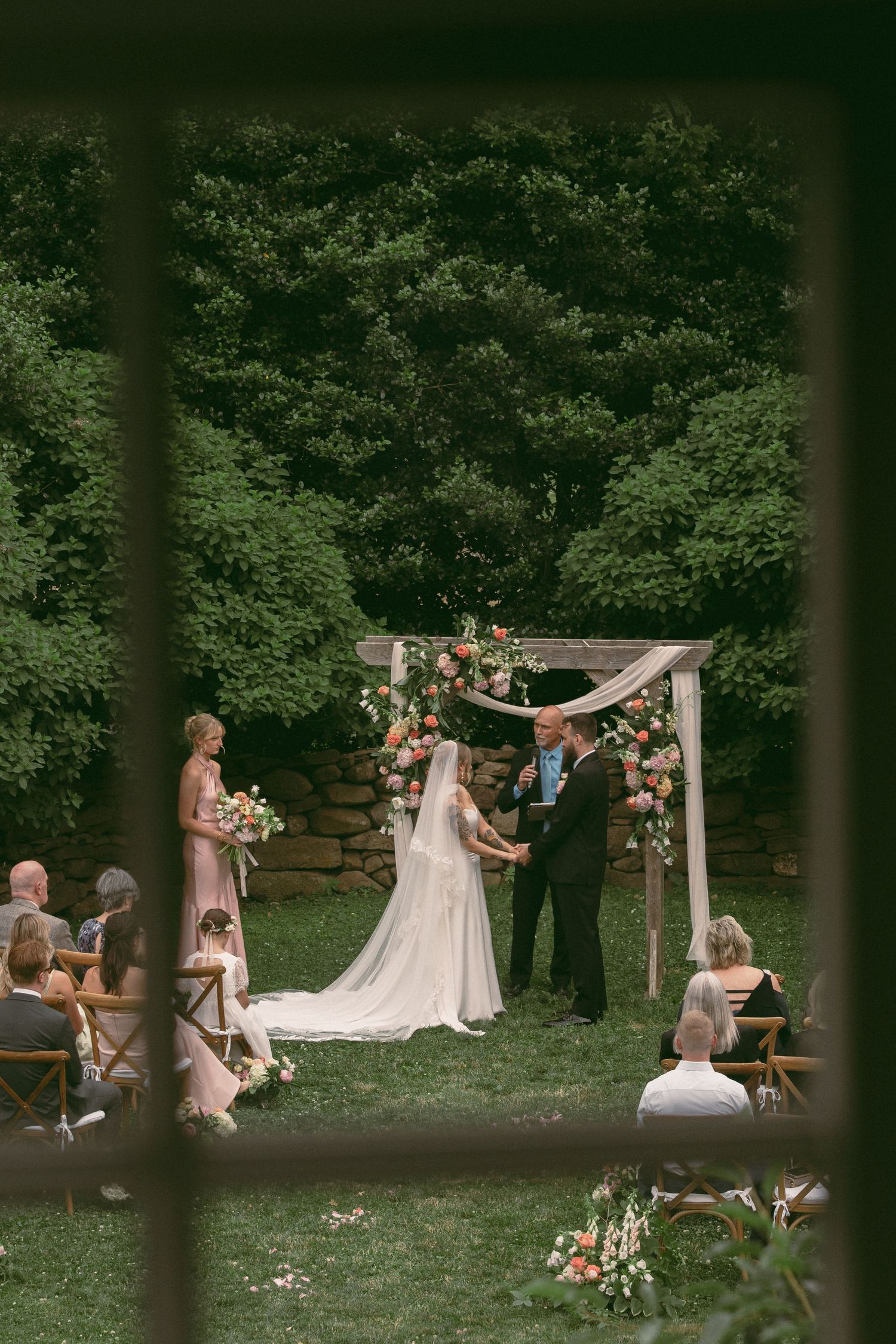 A wedding couple shares an intimate moment in an autumn field with golden trees in the background.