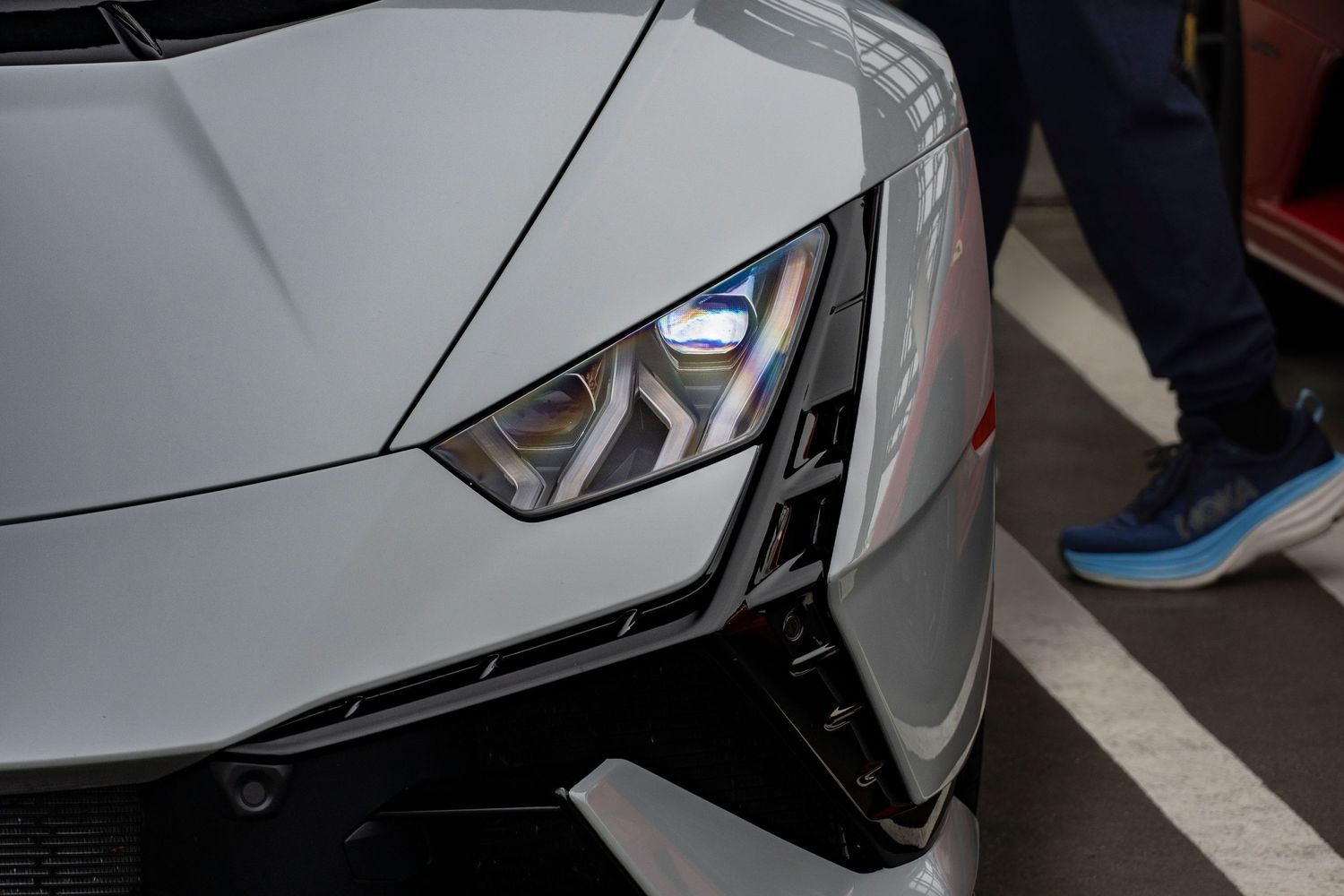 Close-up of Lamborghini Huracan blue LED headlight and front fascia.