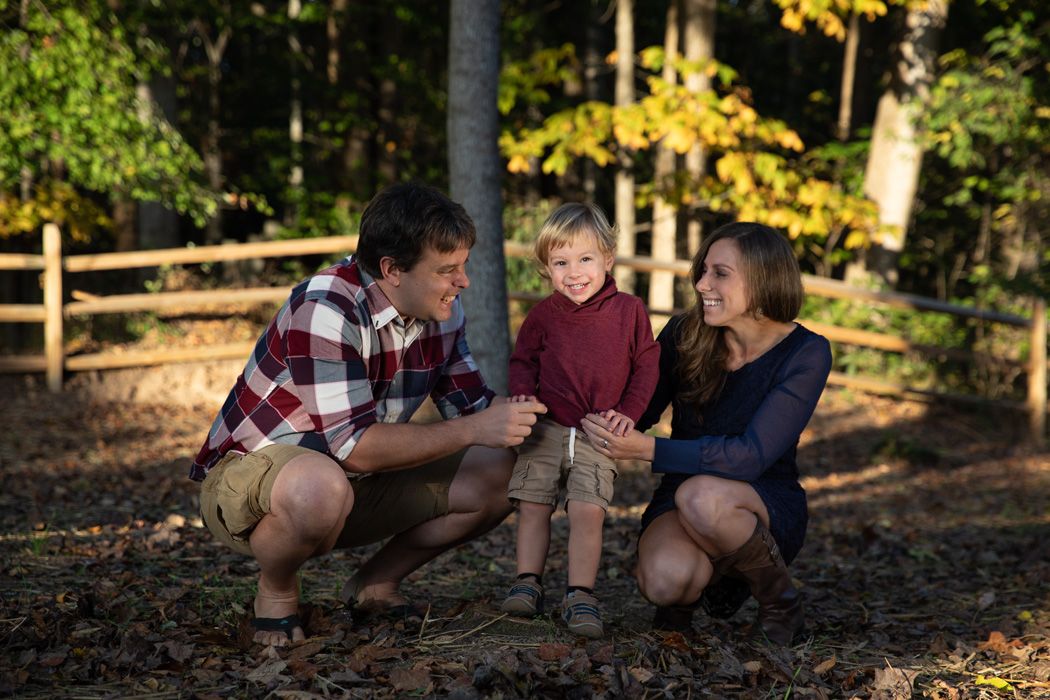 Family enjoying autumn afternoon in wooded setting.