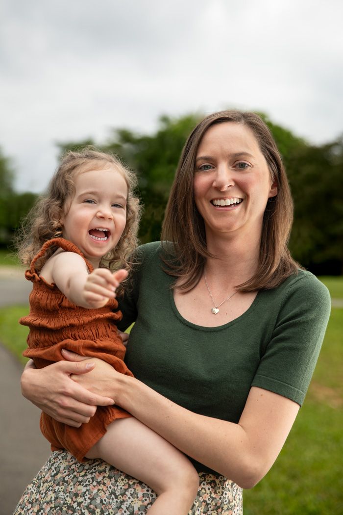 A candid moment of shared laughter between parent and child outdoors.
