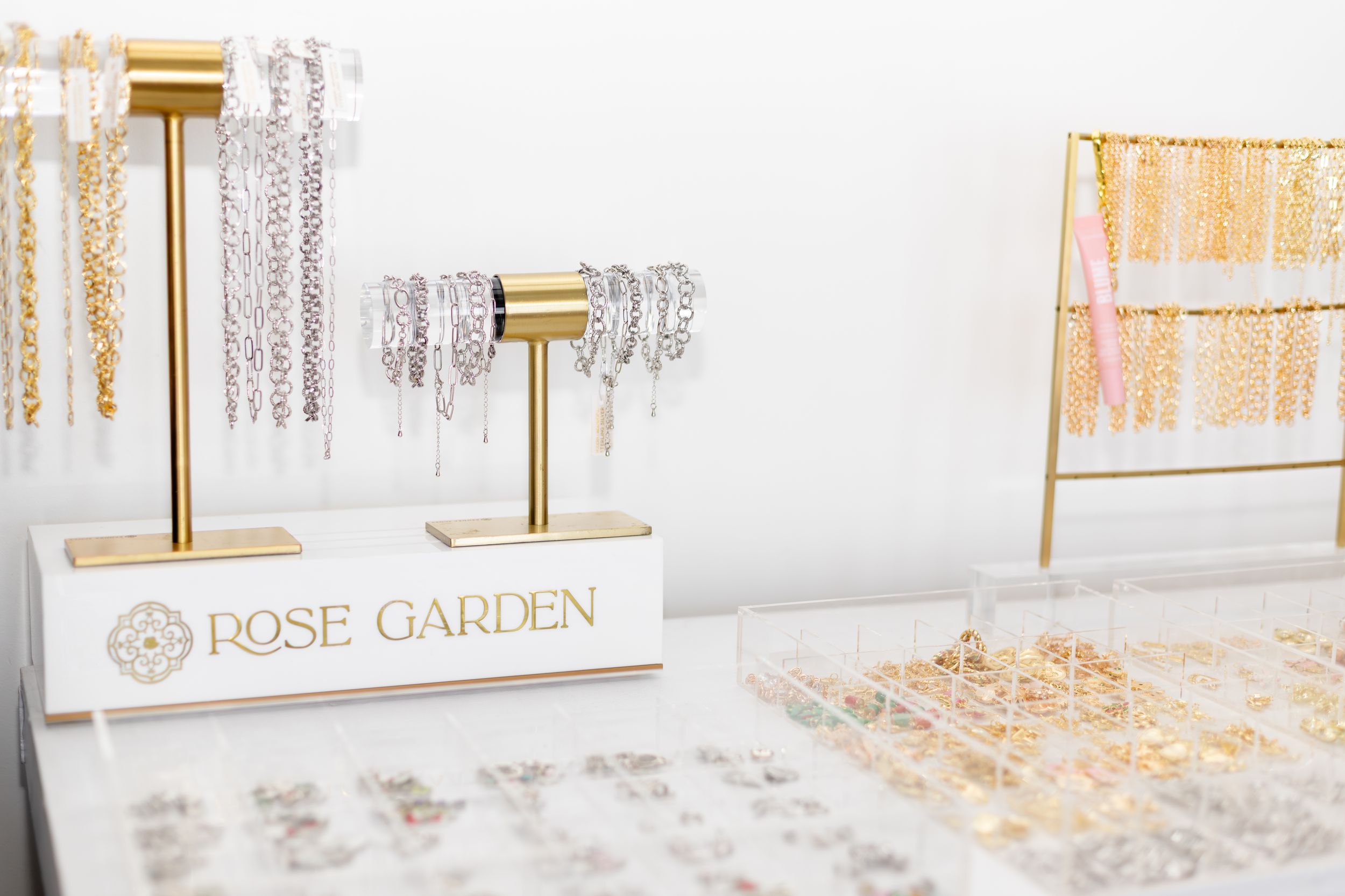 Gold and white bathroom accessories displayed on a marble countertop with elegant glass bottles and soap dispensers.